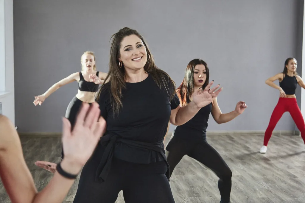 Trainerin leitet einen Fitnesskurs mit mehreren Teilnehmerinnen